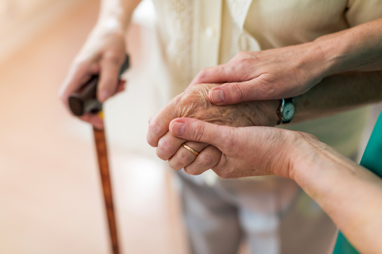 Younger hand resting on an elderly person's hand